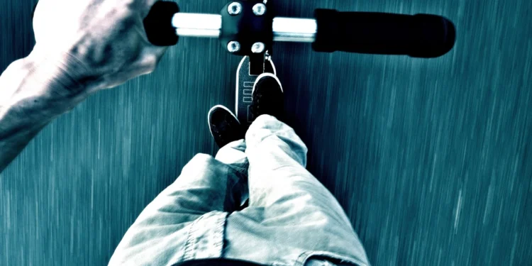 Adult riding an electric scooter like the Yume X7