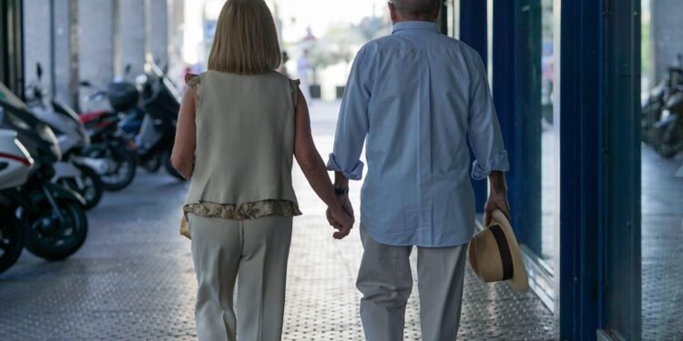 Senior couple walking hand in hand in a senior living community