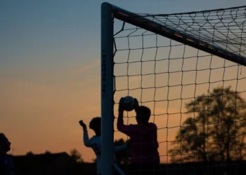Children playing soccer at sunset