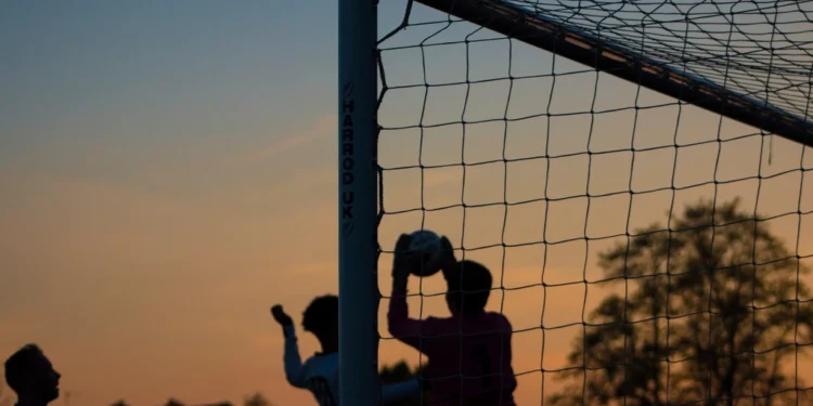 Children playing soccer at sunset