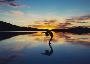 Woman doing yoga at sunset as a practice of self-love