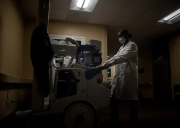 Radiology technologist with X-ray equipment used before spinal surgery