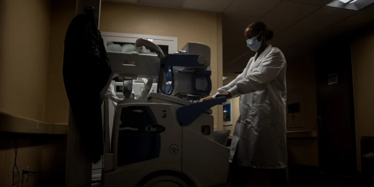 Radiology technologist with X-ray equipment used before spinal surgery