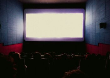 Audience watching one of the action movies of 2025 on a big cinema screen