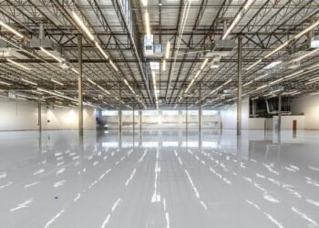 Glossy epoxy flooring reflecting overhead lights in an industrial building