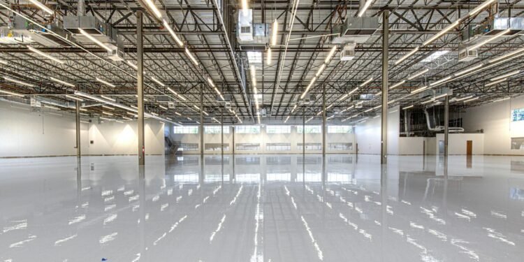 Glossy epoxy flooring reflecting overhead lights in an industrial building