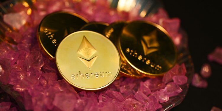 Gold Ethereum coins on pink crystals, illustrating an Ethereum price prediction