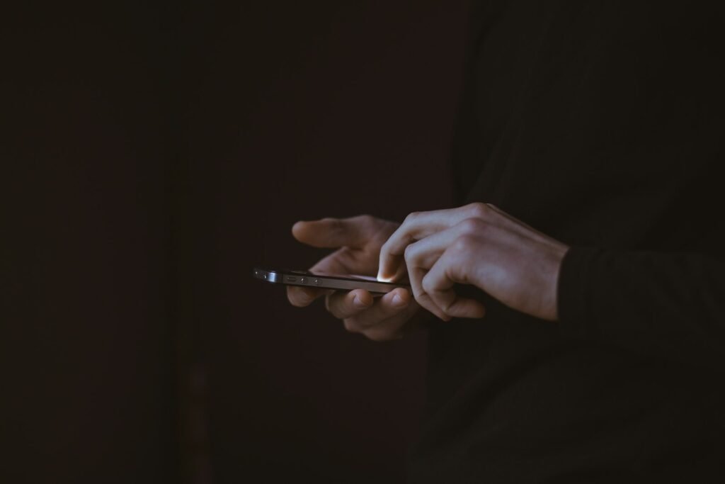Silhouette of a person looking at a smartphone