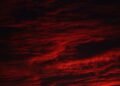 Dark red storm clouds, evoking the Stranger Things Mind Flayer and the Upside Down sky