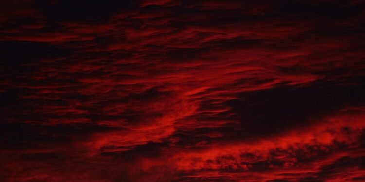 Dark red storm clouds, evoking the Stranger Things Mind Flayer and the Upside Down sky
