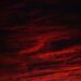 Dark red storm clouds, evoking the Stranger Things Mind Flayer and the Upside Down sky