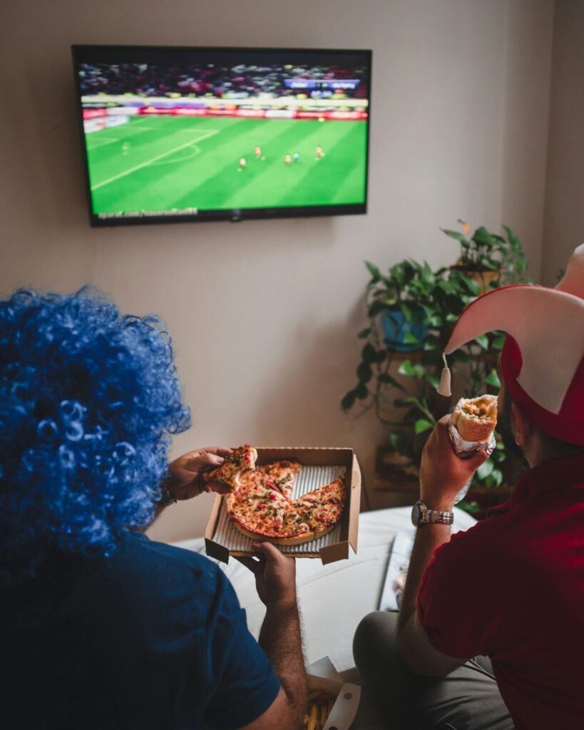 Two people relaxing on a couch while watching TV